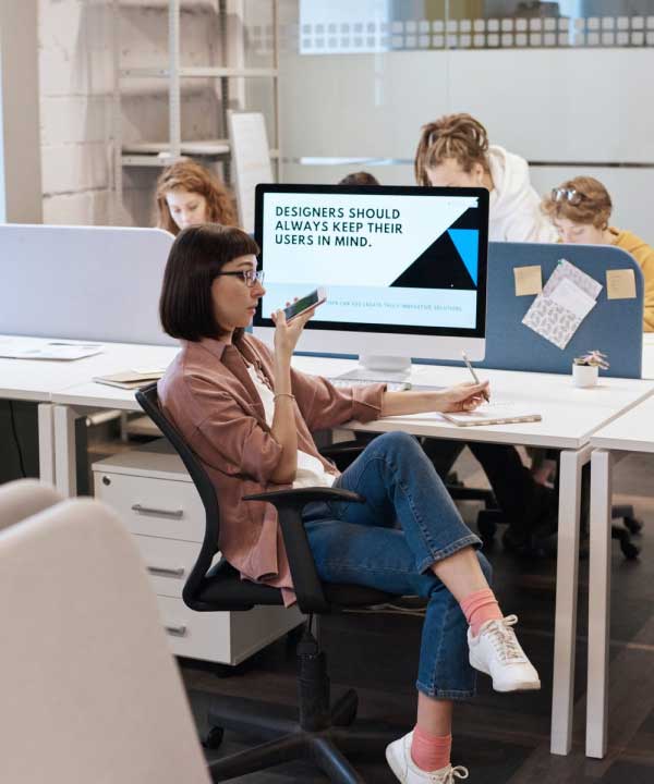 People working together at computers in a bright shared office.